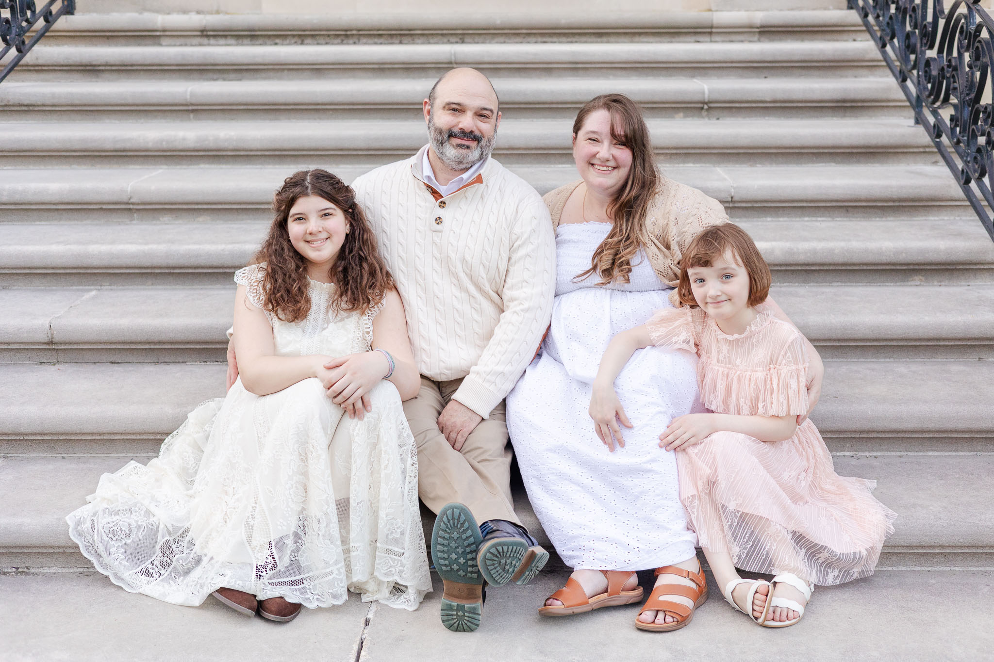 family sitting on steps of vanderbilt mansion in hyde park ny