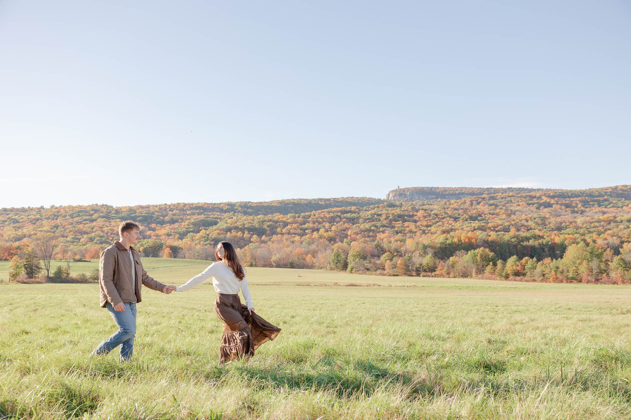 couple walking in field at Mohonk Preserve New Paltz NY at fall engagement session